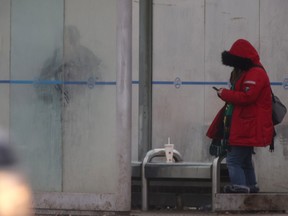 Two people at a bus stop