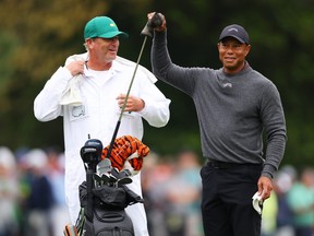 Tiger Woods speaks with his caddie Lance Bennett on the eighth green during a practice round prior to the 2024 Masters Tournament.