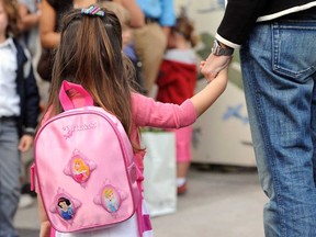 A pupil holds the hand of her mother in the courtyard of Jean Mermoz school on September 4, 2012 prior enter in his classroom for an early start of the new school year in Marseille, southern France.