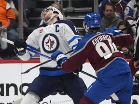 Winnipeg Jets centre Adam Lowry reels after being hit by Colorado Avalanche left winger Joel Kiviranta during the second period of Game 3 of an NHL hockey Stanley Cup first-round playoff series Friday.