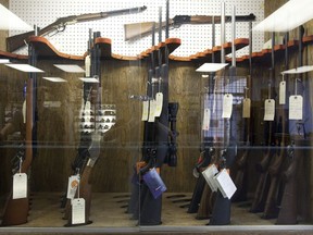 Hunting rifles are seen on display in a glass case at a gun and rifle store in downtown Vancouver.