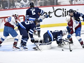 Colorado Avalanche's Joel Kiviranta (94) looks for the loose puck in front of Winnipeg Jets goaltender Connor Hellebuyck (37) during the second period in Game 2 of their NHL hockey Stanley Cup first-round playoff series in Winnipeg, Tuesday April 23, 2024.