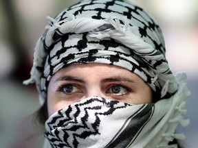 A woman wears a keffiyeh during a rally in support of Palestinians. The scarf's ubiquity in anti-Israel protests since Hamas’s October 7 attacks has made it a divisive symbol for many of Israel’s supporters.