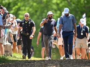 Mark Hubbard, centre, of the United States and Scottie Scheffler, right, of the United States walk to the 12th tee during the final round of the 2024 PGA Championship at Valhalla Golf Club on May 19, 2024, in Louisville, Ky.
