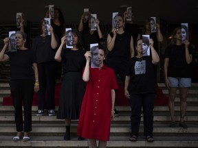 Relatives and supporters of Israeli hostages held by Hamas in Gaza hold photos of their loved ones during a performance calling for their return in Tel Aviv, Israel, Thursday, May 23, 2024.