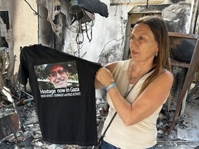 Rita Lifshitz, holding up a shirt bearing a photo of her father-in-law, peace activist Oded Lifshitz, who is still held captive somewhere in Gaza. WARREN KINSELLA/TORONTO SUN