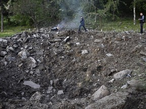 Police officers inspect a crater after a Russian missile attack in Zaporizhzhia, Ukraine, Wednesday, May 8, 2024.