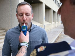 An RCMP office administers a breath test