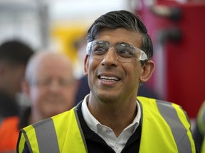 Britain's Prime Minister leader of the Conservative Party, Rishi Sunak, talks to students as he looks at a green hydrogen demonstrator during a general election campaign visit to the Redcar and Cleveland college in Redcar, northeast England, on June 28, 2024. (Photo by Kin Cheung / POOL / AFP)