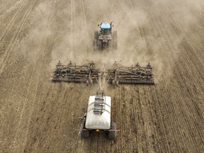 A wetter-than-expected spring has Western Canadian farmers breathing a sigh of relief, but the threat of drought remains. This file photo shows a farmer driving a seeding rig as he plants a canola crop on their family's farm near Cremona, Alta.